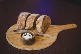 Sliced Artisan Bread with Herb Butter on Wooden Board