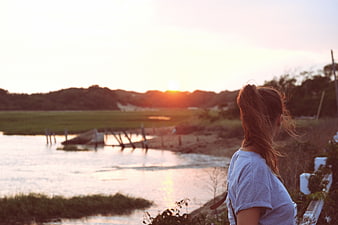 Woman Watching Sunset Over River Landscape