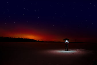 Lone figure with umbrella under starry night sky