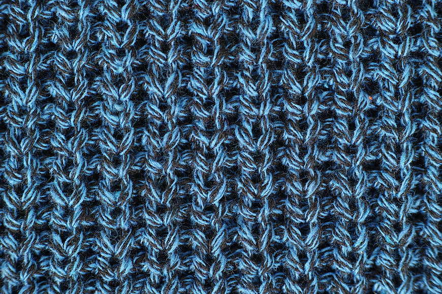 Close-up of blue and black knitted wool sweater texture