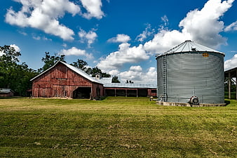 Red Barn and Metal Silo on Green Farm Field
