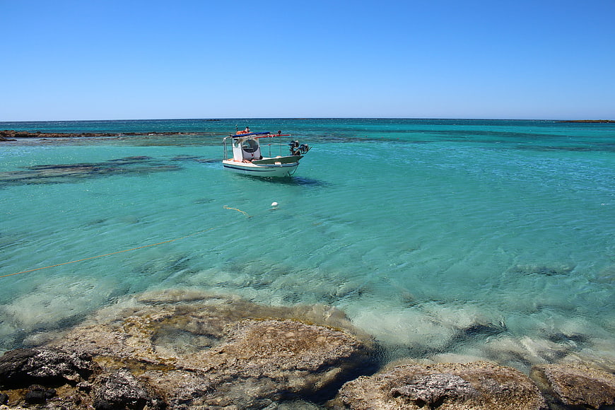 Small boat anchored in clear turquoise tropical waters
