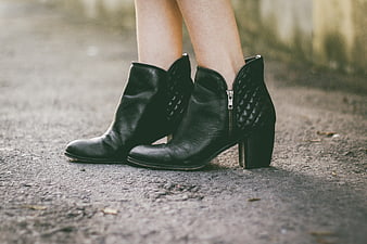 Close-up of black leather ankle boots on pavement