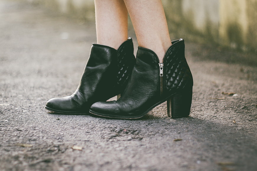 Close-up of black leather ankle boots on pavement