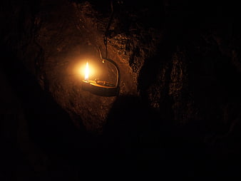 Single Oil Lamp Hanging in Dark Cave