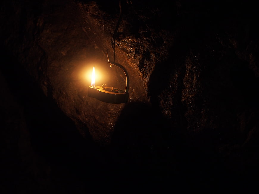 Single Oil Lamp Hanging in Dark Cave