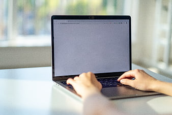 Hands Typing on Laptop in Bright Office Workspace