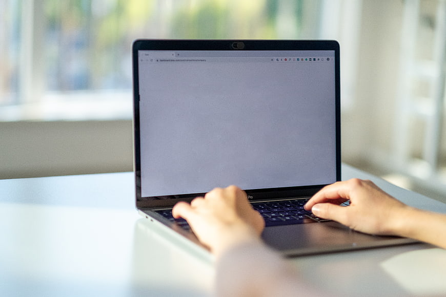 Hands Typing on Laptop in Bright Office Workspace