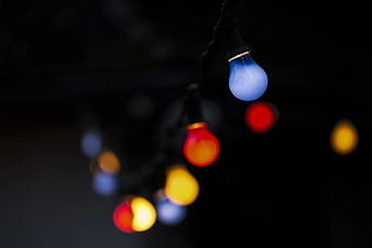 Colorful Christmas Lights Hanging Against Dark Background
