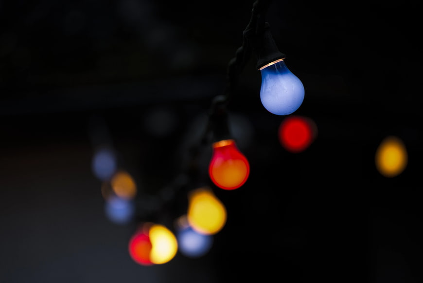 Colorful Christmas Lights Hanging Against Dark Background