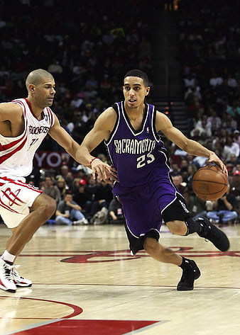 NBA Basketball Player Dribbling Past Defender in Arena