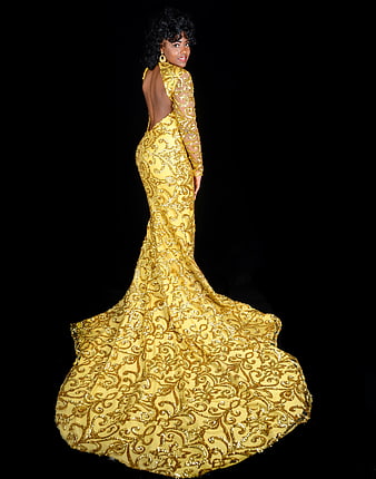 Elegant woman in gold sequined prom gown with long train