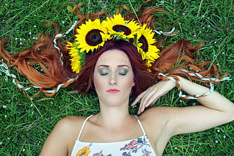 Woman with Sunflower Crown Lying in Green Grass