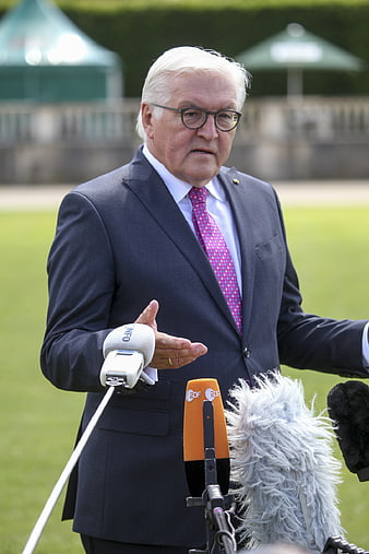 Senior politician in suit speaking to press with microphones