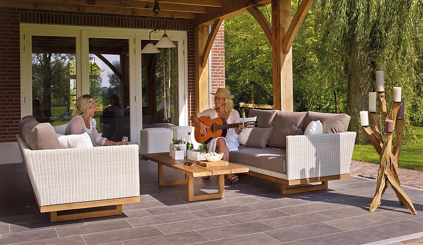 Two women relaxing on patio with guitar and outdoor furniture