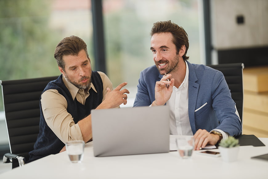 Two Businessmen Discussing Strategy at Office Desk