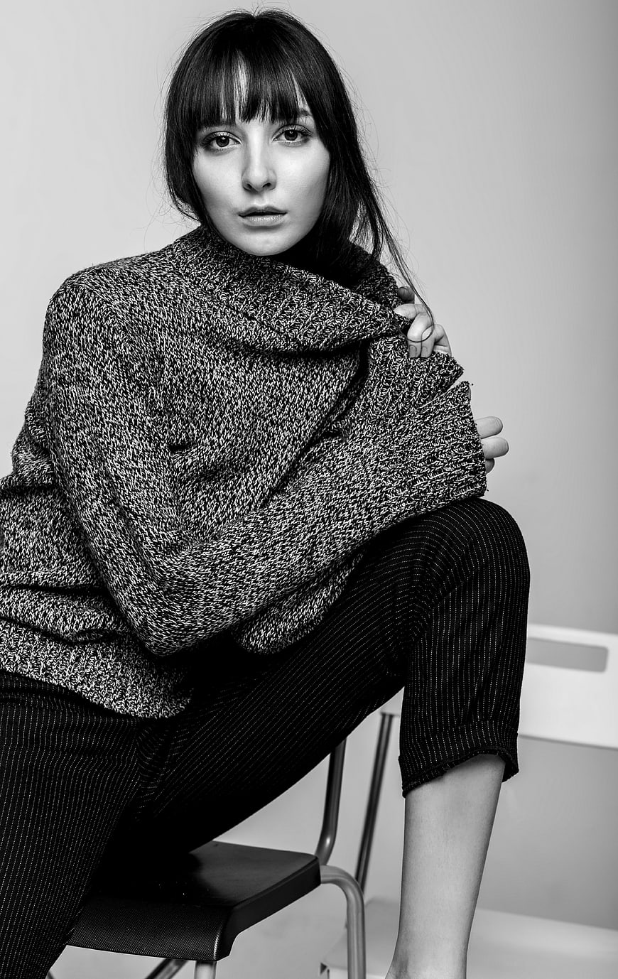 Black and white portrait of woman in oversized knit sweater