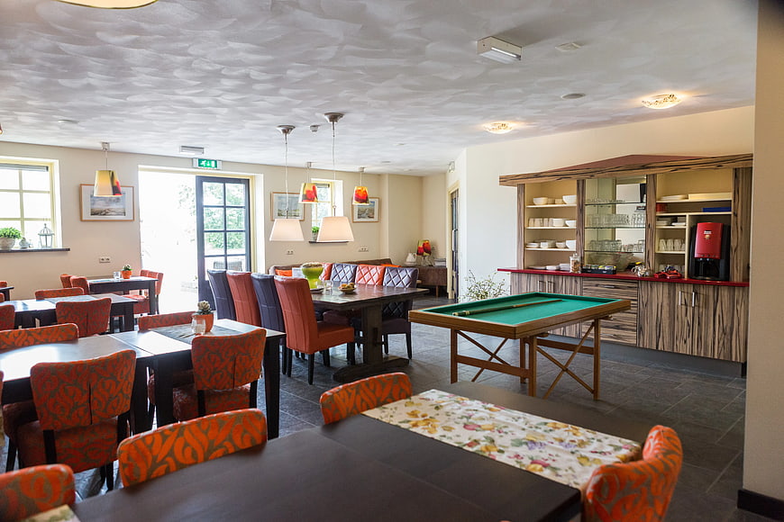 Spacious hotel lounge with pool table and dining area