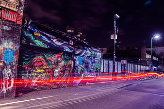 Urban Night Street With Colorful Graffiti And Red Light Trails