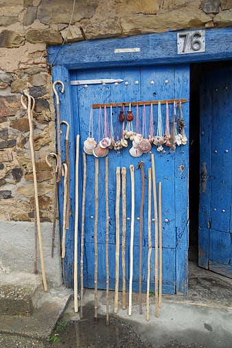 Pilgrim Sticks and Seashell Necklaces on Blue Wooden Door