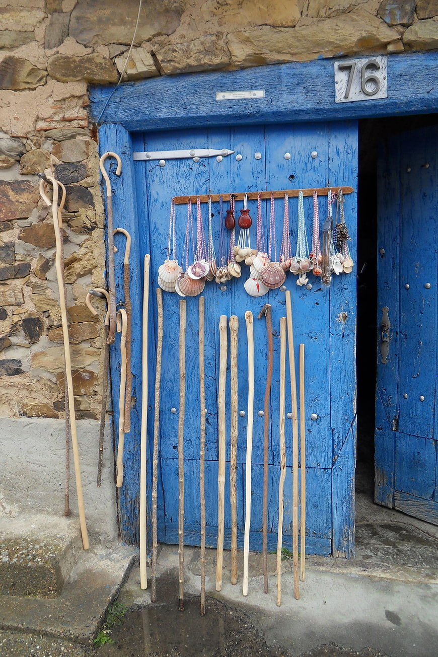 Pilgrim Sticks and Seashell Necklaces on Blue Wooden Door