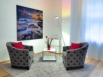 Modern living room with patterned tub chairs and red accents