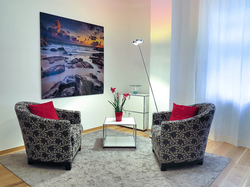 Modern living room with patterned tub chairs and red accents