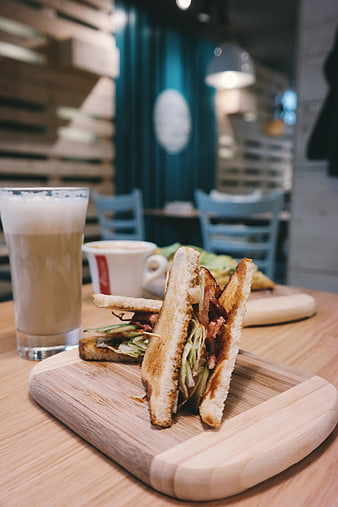 Delicious toasted sandwich and iced coffee on wooden board