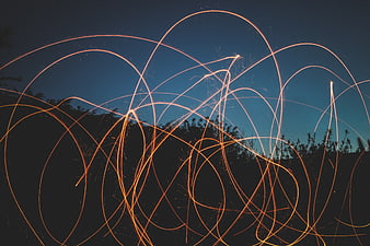 Steel wool light painting sparks against twilight sky