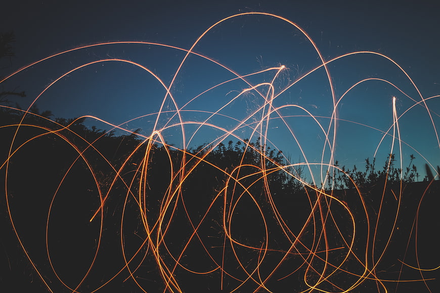 Steel wool light painting sparks against twilight sky