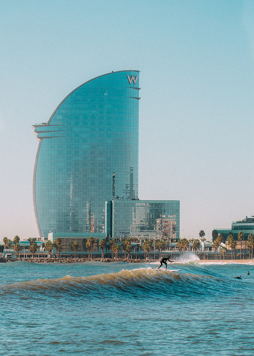 Surfer riding wave in front of W Hotel Dubai skyline