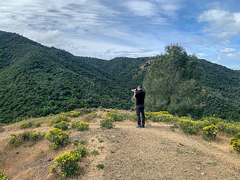 Photographer capturing mountain landscape with camera