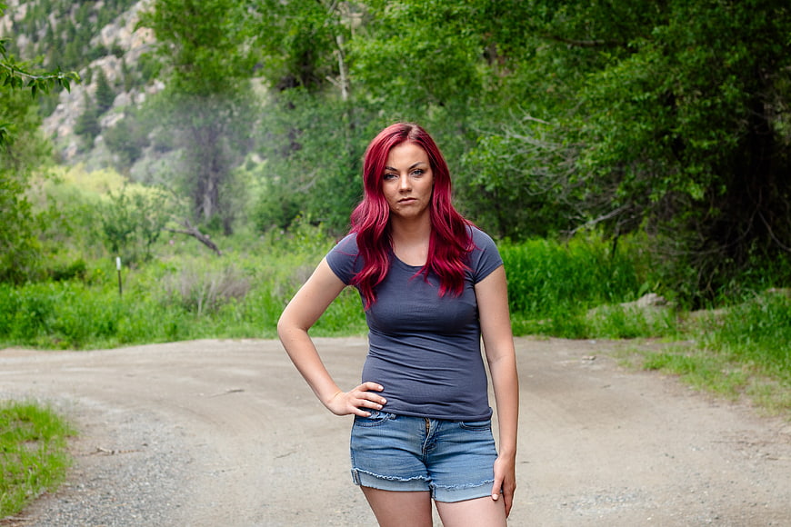 Woman with Red Hair Standing on Dirt Road in Nature