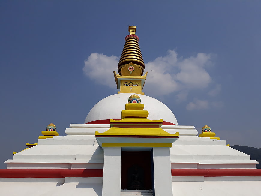 White Buddhist Stupa with Golden Spire and Buddha Eyes