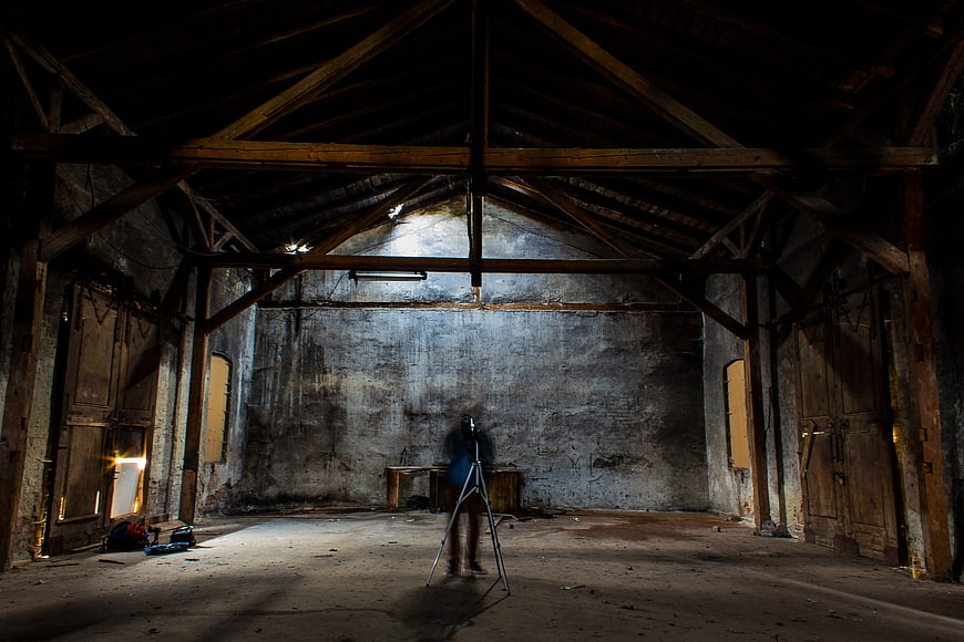 Abandoned Barn Interior with Photographer and Tripod
