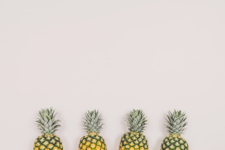 Minimalist Row of Pineapples on White Background