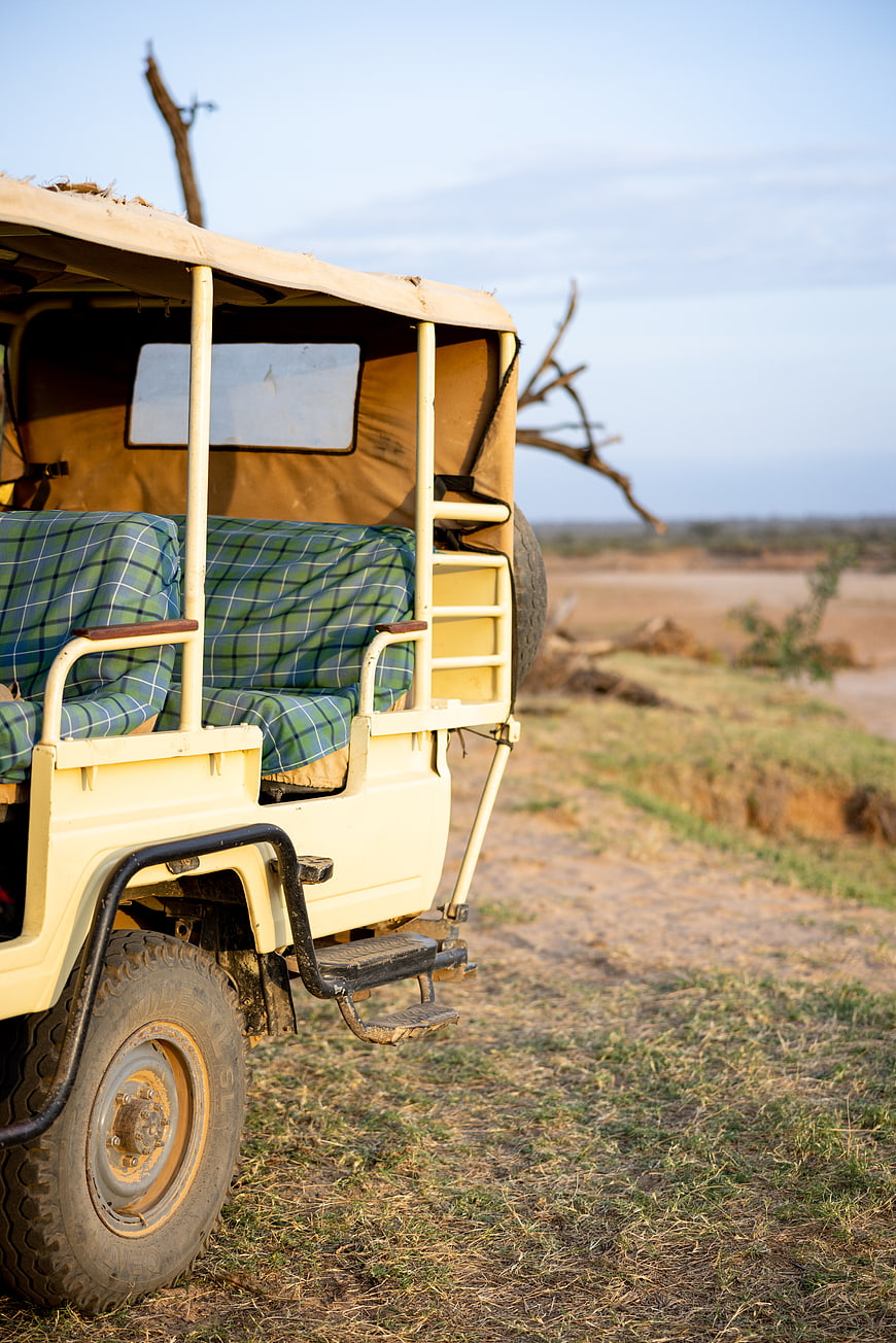 Safari Jeep Parked on Gravel Road in African Savanna