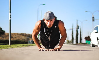 Athletic man in low crouch on asphalt road