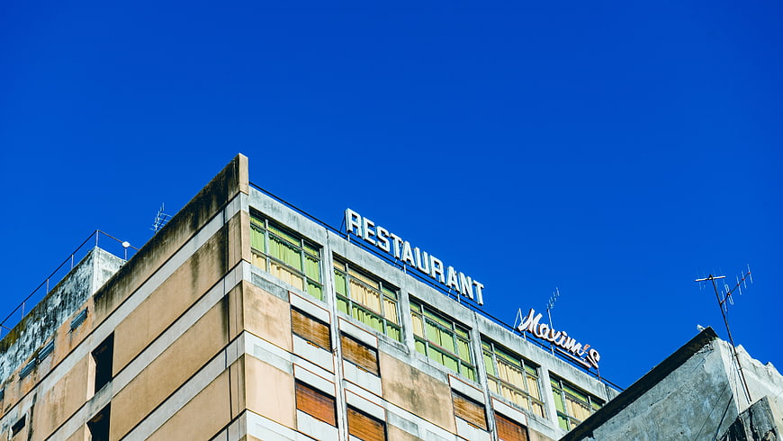 Retro Restaurant Building Sign Against Blue Sky