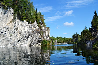 Serene Marble Quarry Lake with Rocky Cliffs and Pine Forest