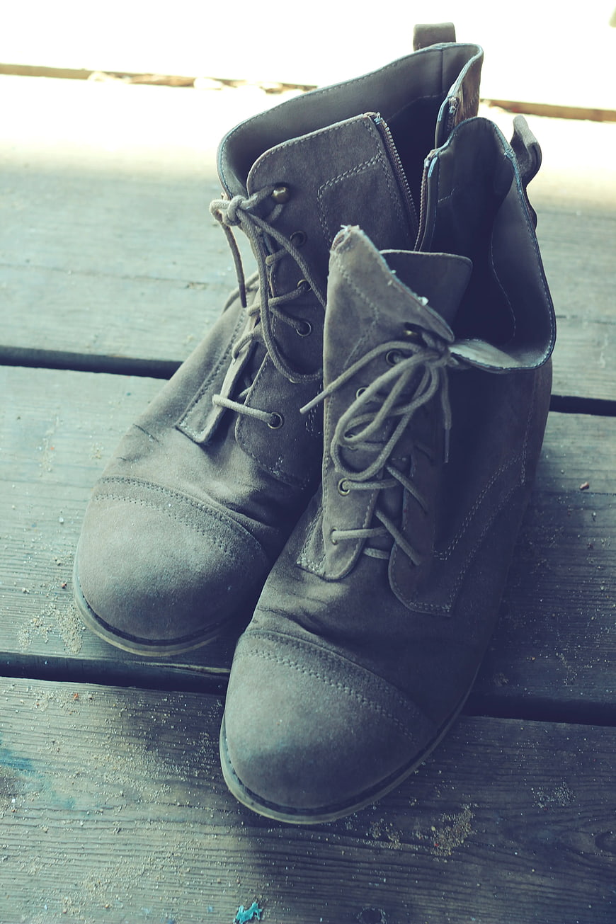 Vintage gray suede boots on weathered wooden deck