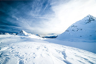 Snowy mountain landscape with blue sky and clouds