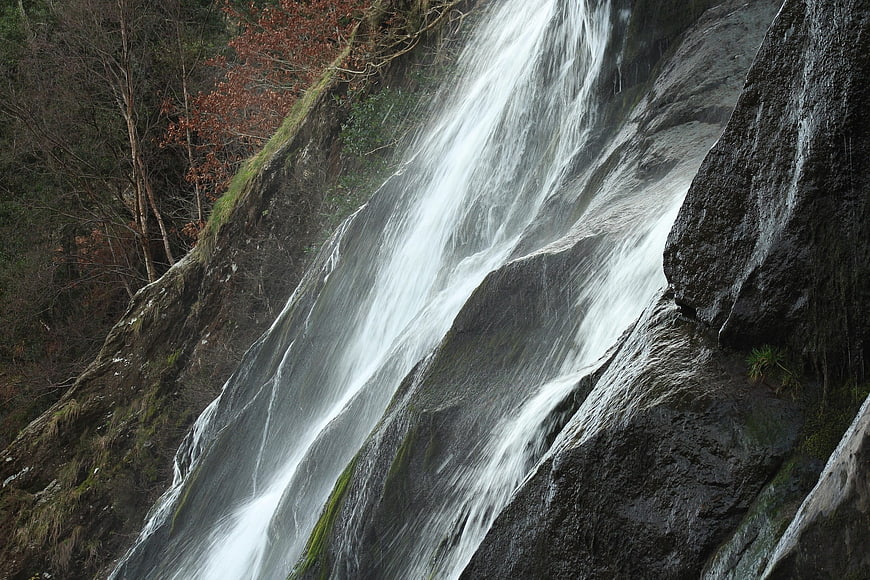 Waterfall cascading down dark rocky cliff face
