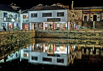 Night reflection of traditional Chinese architecture in canal water