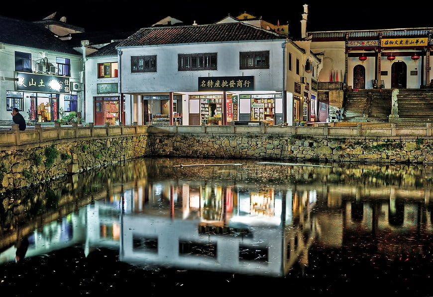 Night reflection of traditional Chinese architecture in canal water