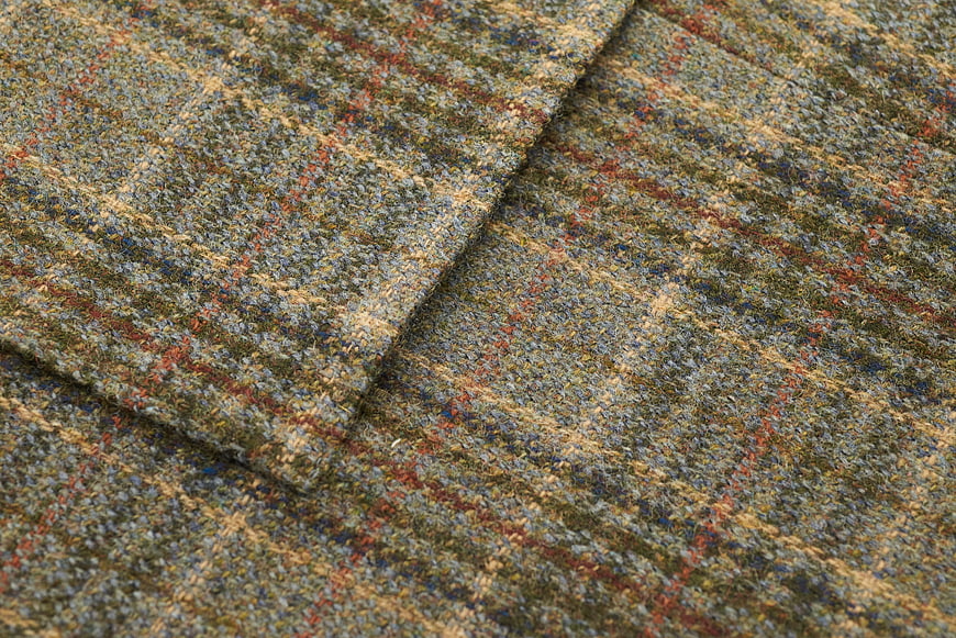 Close-up of textured tweed fabric with plaid pattern
