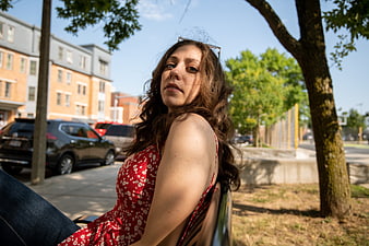 Young Woman in Red Dress Sitting on Park Bench