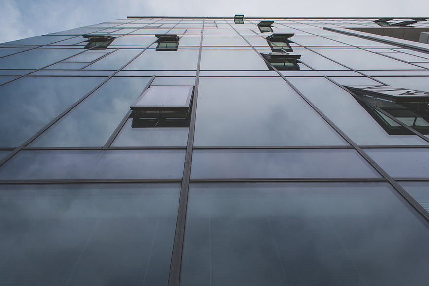 Low angle view of modern glass office building facade