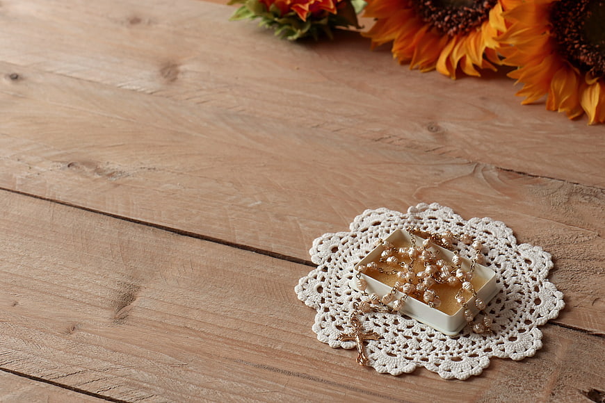 Pearl Rosary on Lace Doily with Sunflowers on Wood