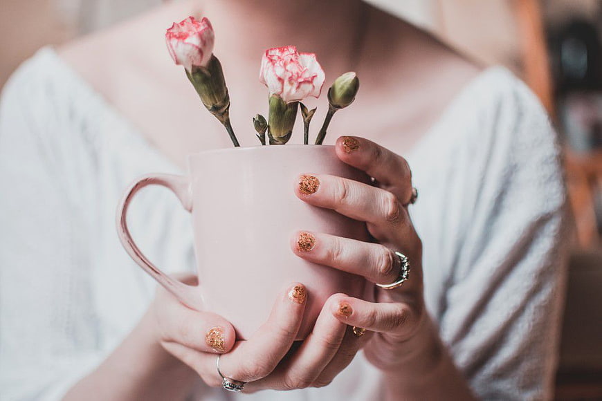 Woman Holding Pink Mug with Carnations